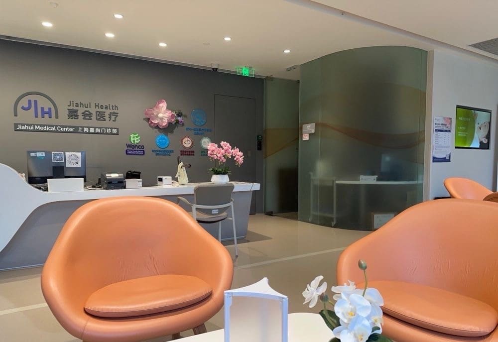 Jiahui Health medical center reception with orange armchairs and bilingual signage, Shanghai