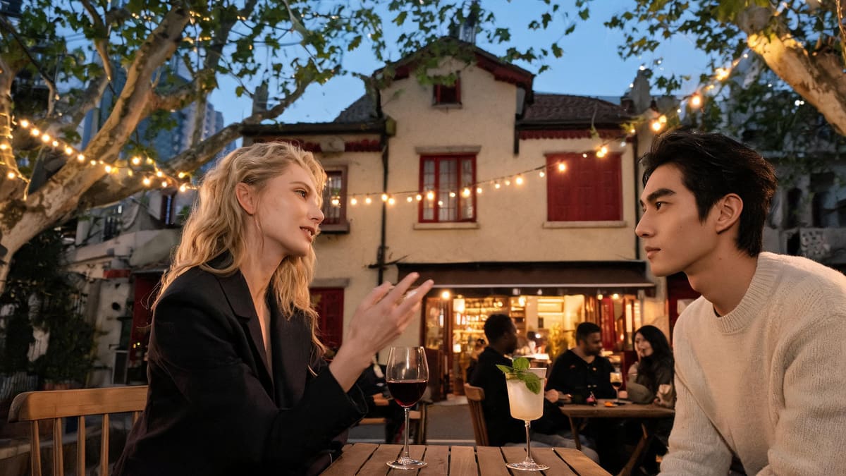 Two friends over wine and a cocktail at a plane-tree street bar on a Xuhui lane, other patrons in the background