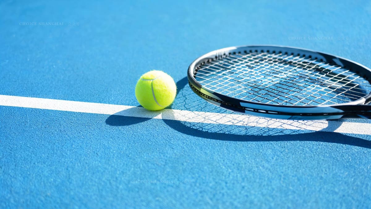A yellow tennis ball and racquet on the white baseline of a blue hard court at the Shanghai Masters