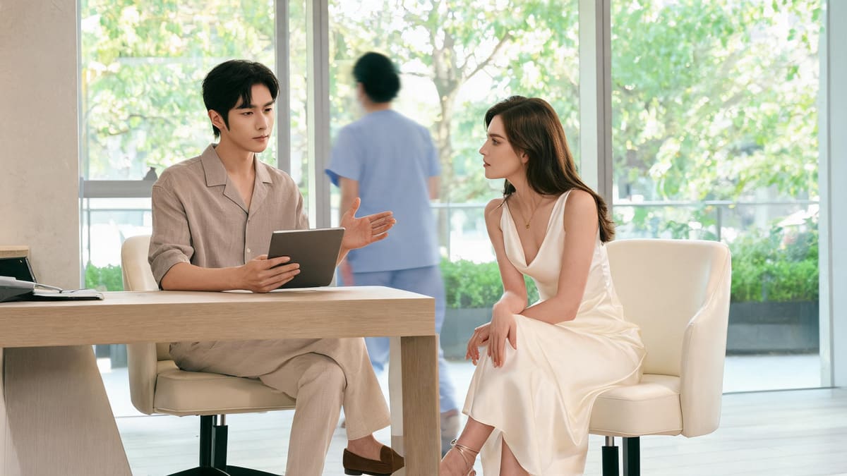 A doctor explaining a treatment to a seated client in a bright consultation room