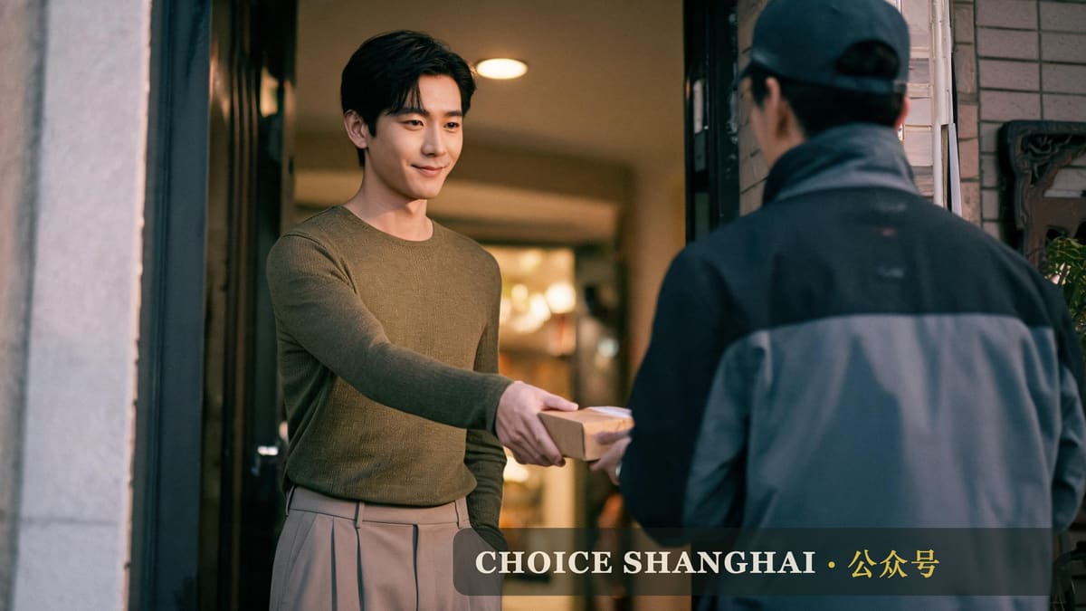 A man receives a late parcel at his Shanghai apartment door, the fast-delivery habit expats carry home