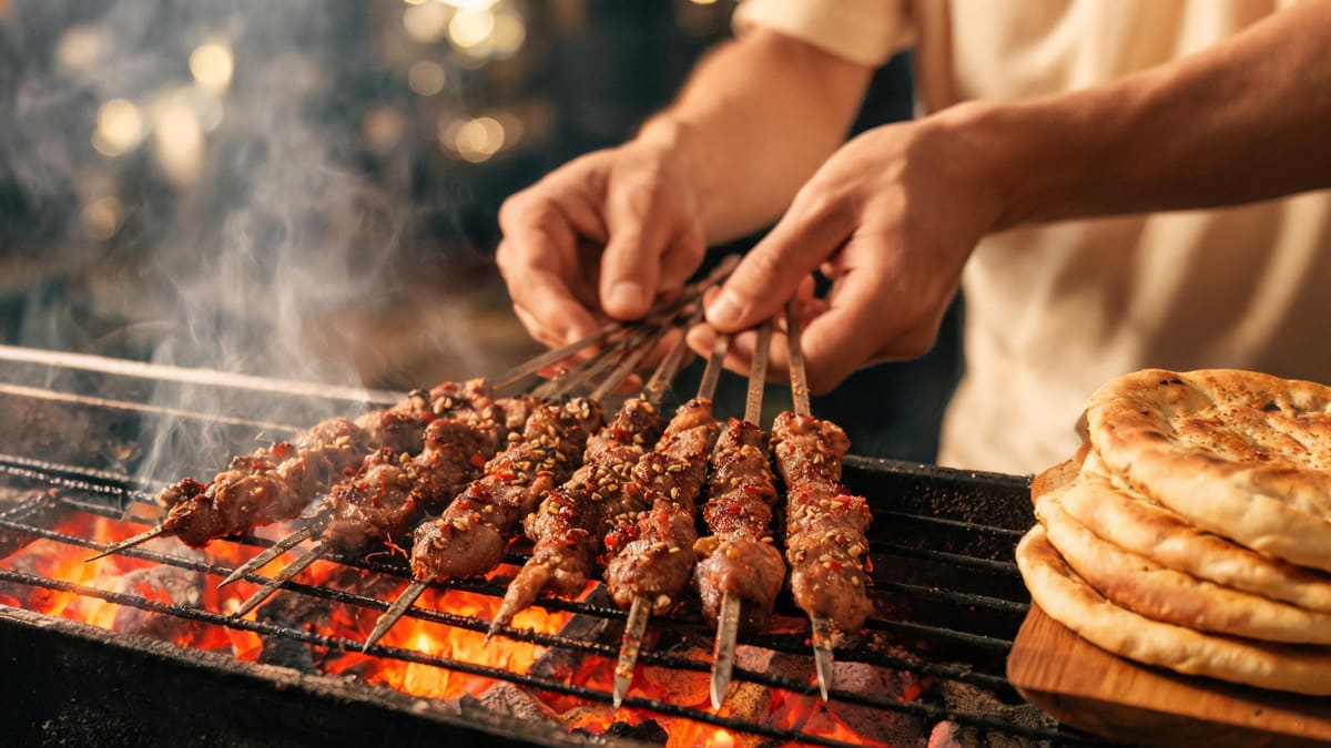 Cumin lamb skewers grilling over charcoal beside a stack of golden naan at a Shanghai halal restaurant