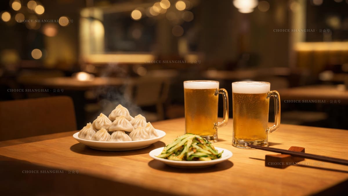 A shared Shanghai dinner table at night with small plates of dumplings, cold dishes and two glasses of beer