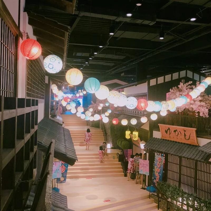 上海・莘荘の日系温泉「涟泉大江戸」、提灯と桜で飾られた江戸風の館内通りを浴衣姿で歩く来館者
