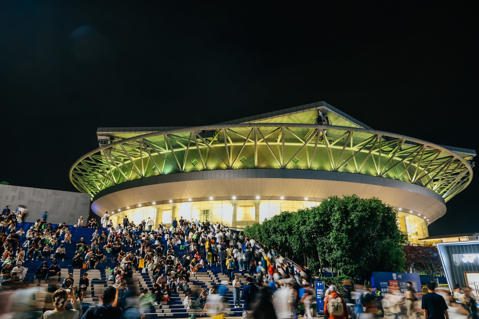 Qizhong Tennis Center lit up at night with crowds on the steps at the Shanghai Masters