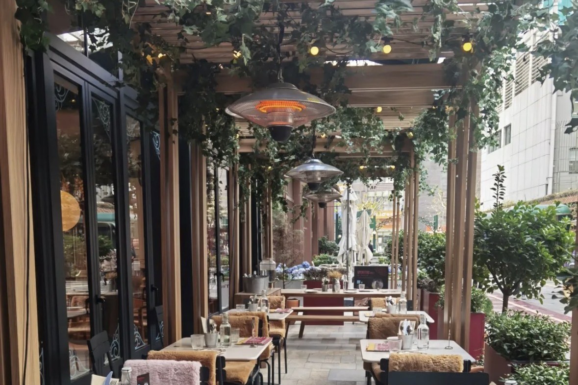 Momenti's canopy-shaded terrace along the Hong Shou Fang pedestrian lane, draped in greenery with warm lighting