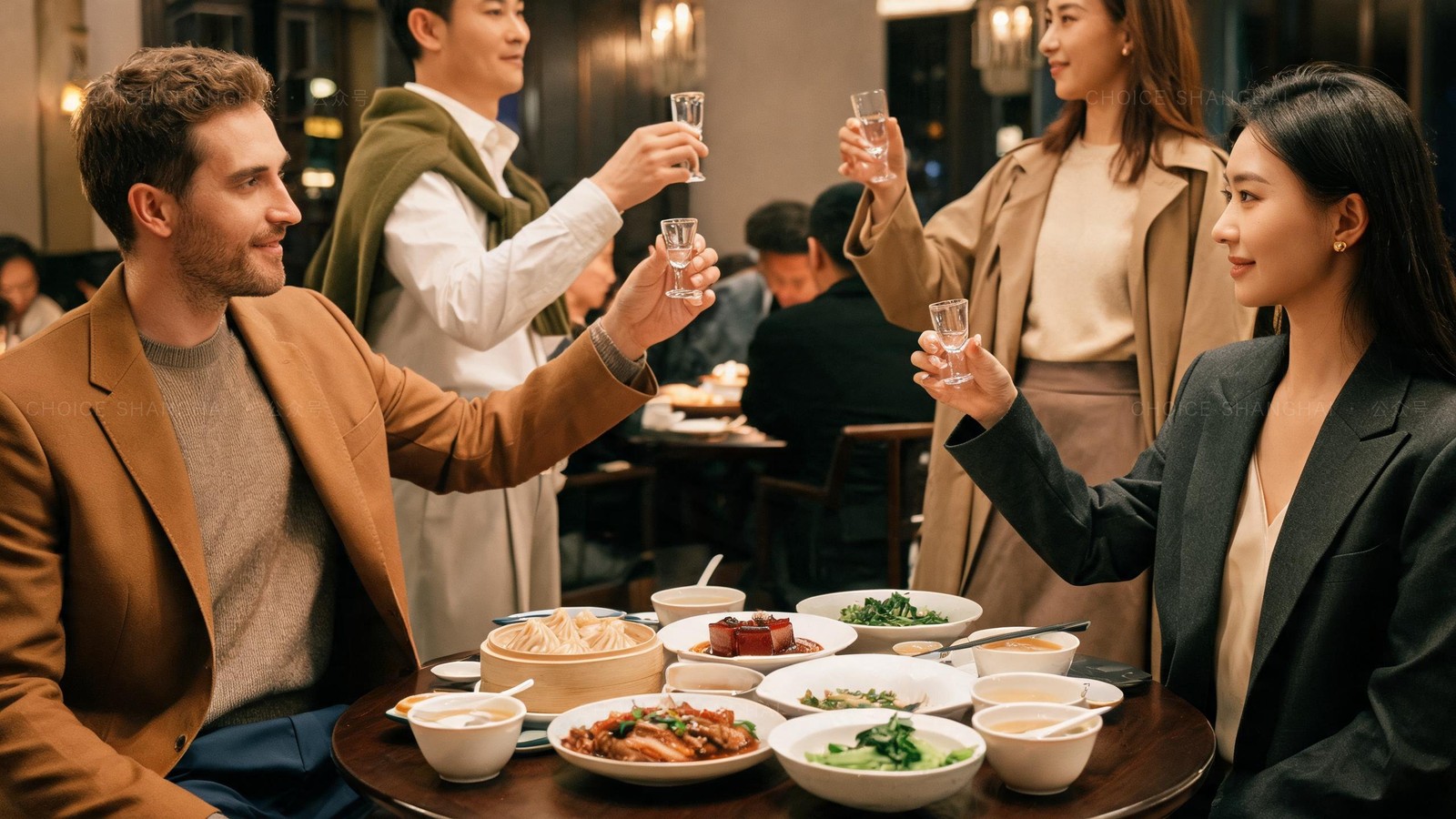 Hands raising small glasses in a toast over a round table of dishes at a Shanghai work dinner, one glass held lower in respect