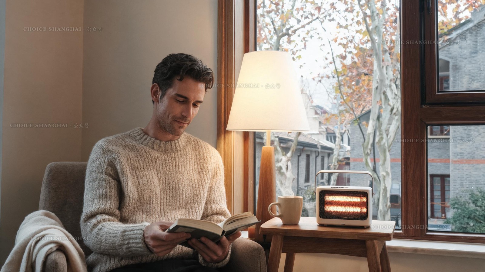 A man in a chunky oatmeal knit reading by a warm lamp and glowing space heater with tea, grey Shanghai winter outside the window