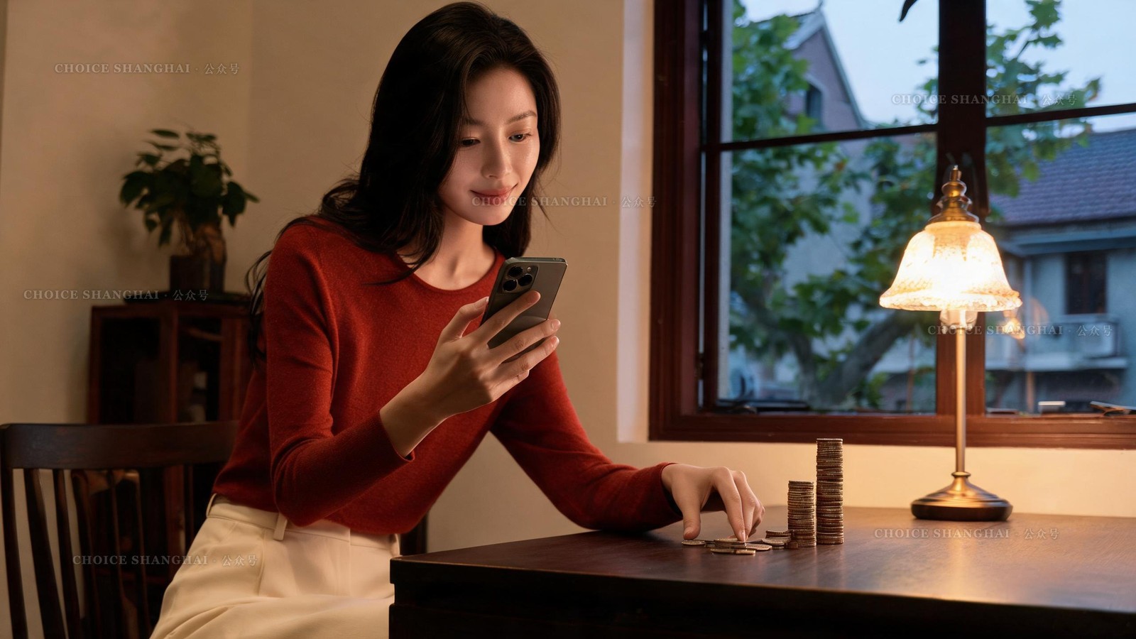 A woman in a rust knit top sets a phone alarm at a lamp-lit Shanghai table while sliding a small stack of coins toward a larger one
