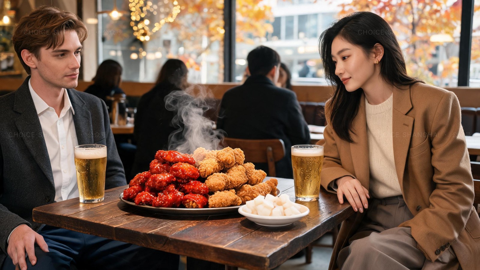 Platter of Korean fried chicken, half glossy red sweet-spicy and half golden crisp, with pickled white radish and two glasses of cold draft beer on a wooden table