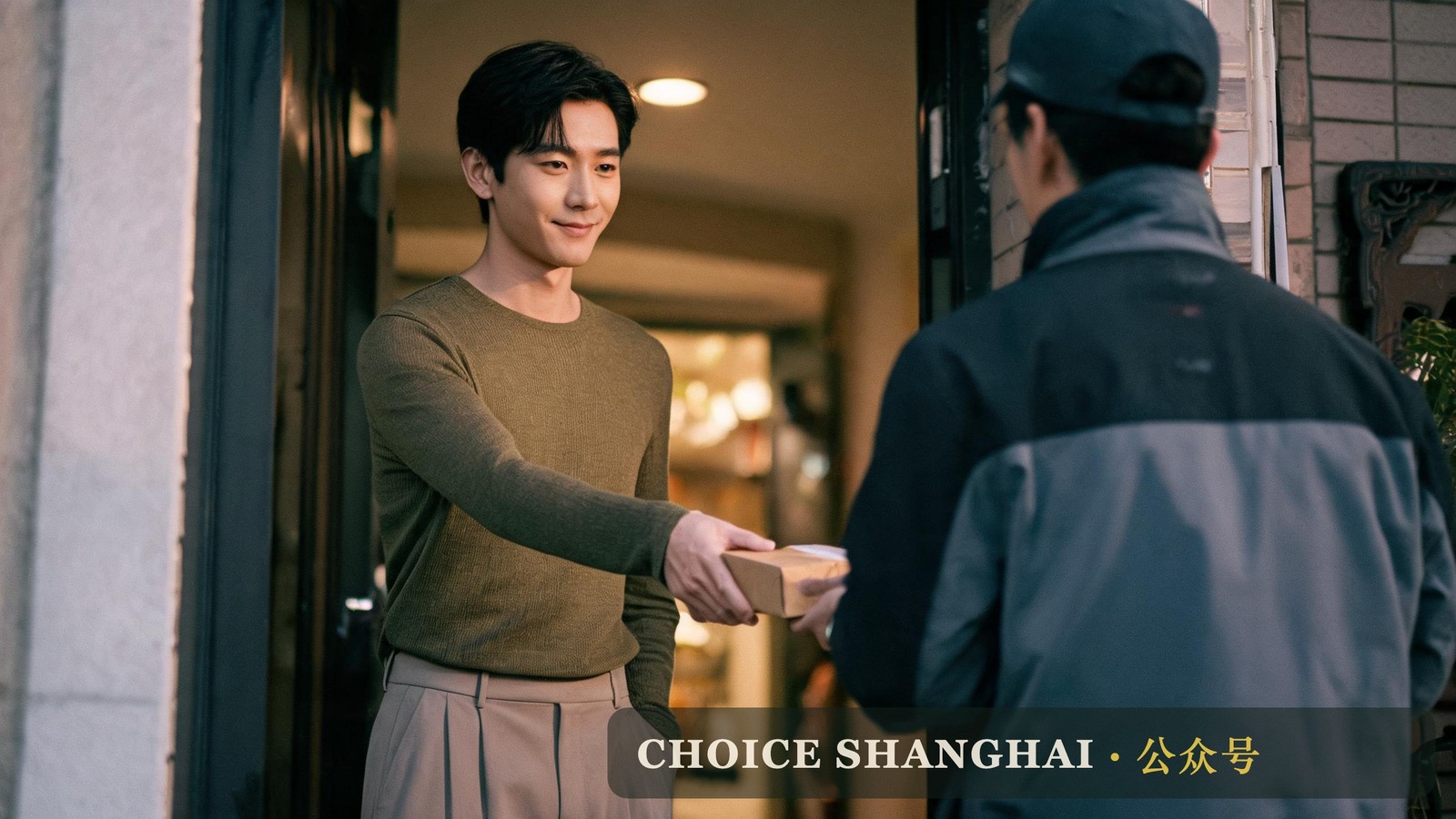 A man receives a late parcel at his Shanghai apartment door, the fast-delivery habit expats carry home