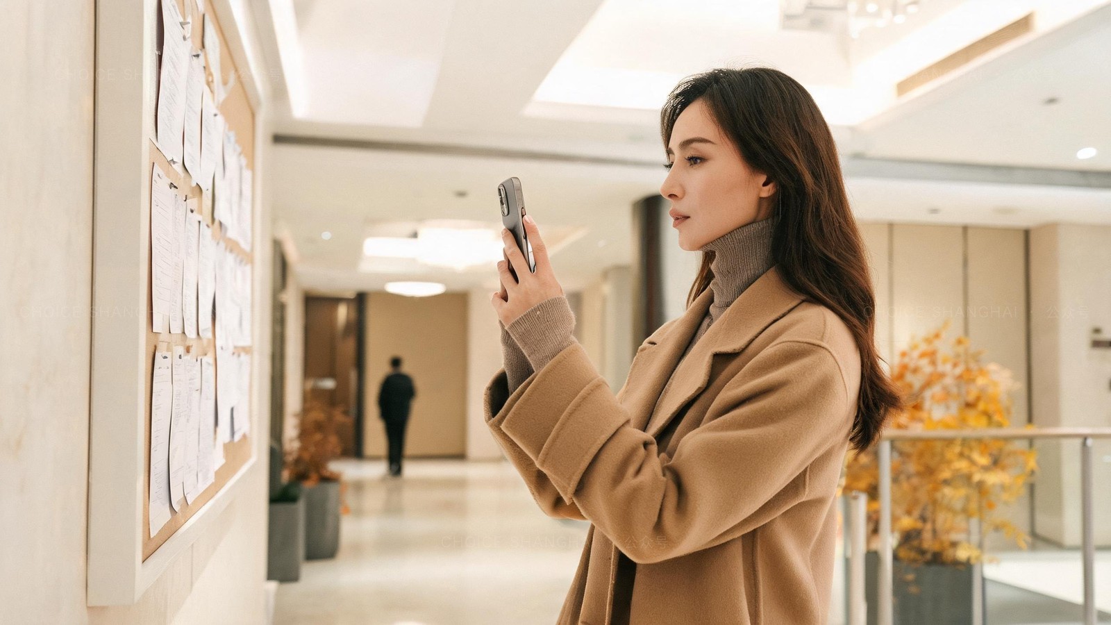 A woman photographing the posted contact numbers on a notice board in the lobby of a Shanghai residential building