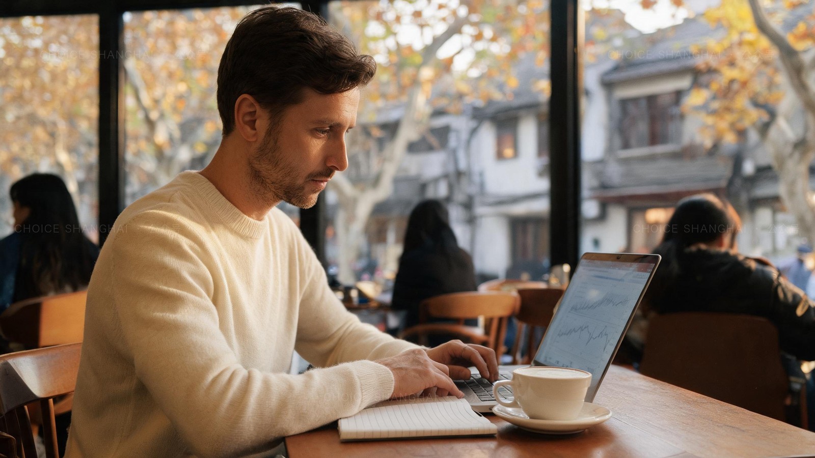 An expat reviewing household budget figures on a laptop at a sunny Shanghai cafe in autumn