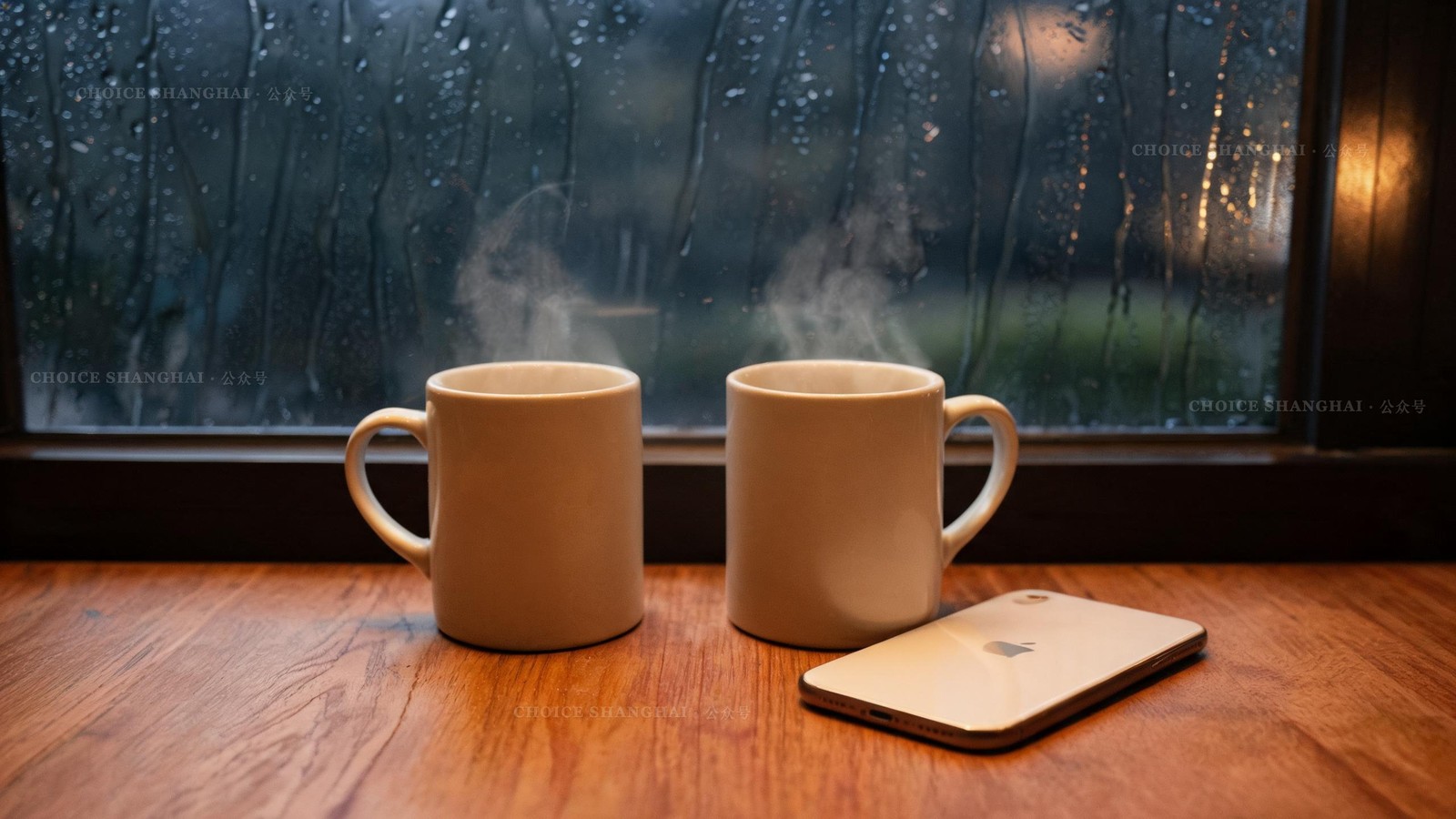 Two ceramic mugs beside a phone lying face down on a wooden table by a rain-streaked window, warm indoor light, a sense of a long-distance call
