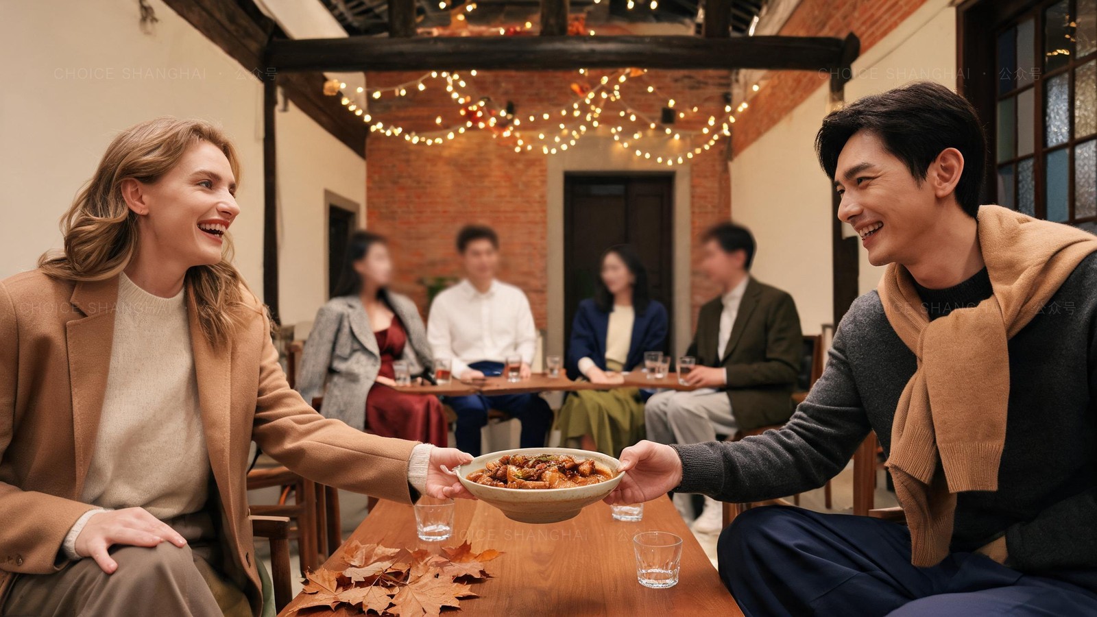 Friends passing a shared dish at a candlelit community holiday dinner in a brick Shanghai lane house with string lights